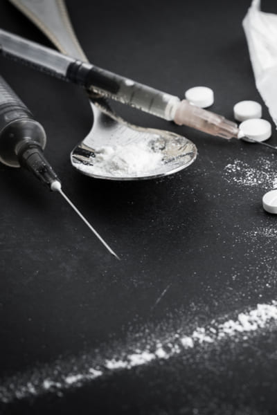 Шприцы с наркотиками на черном столе